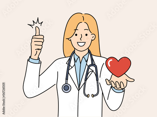 Woman doctor from in hospital with heart in hand smiling and showing thumb up