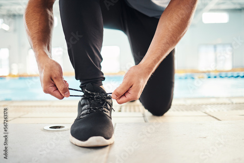 Lace shoes  swimming coach and man on ground for workout  training and wellness. Closeup guy tie sneakers for pool exercise  sports and water performance for healthy body  fitness goals and footwear