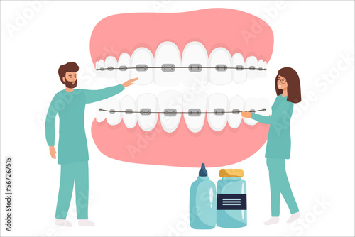 Orthodontist installs dental braces for straightening. Tiny Dentist doctor research X-ray picture of tooth. Dentistry, braces installation, teeth alignment. Prosthetics, Orthodontic treatment,