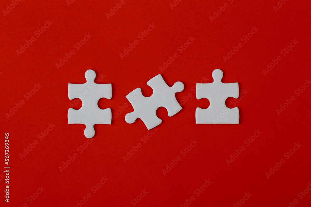 White puzzle pieces on a red background White puzzle pieces on a red background