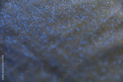 Defocused blurred blackfabric with sparkling blue lurex as background photo