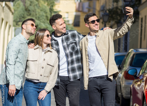 Group of cheerful young friends taking selfie portrait. Happy people looking at the camera smiling. Concept of community, youth lifestyle and friendship 