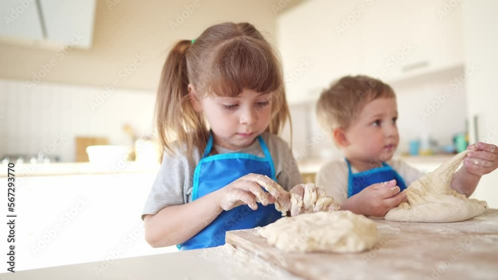 children making dough in the kitchen. baby boy cook in the kitchen knead dough and flour indoors. happy family kid dream lifestyle concept. children play cooking dough together at home children making dough in the kitchen. baby boy cook in the kitchen knead dough and flour indoors. happy family kid dream lifestyle concept. children play cooking dough together at home