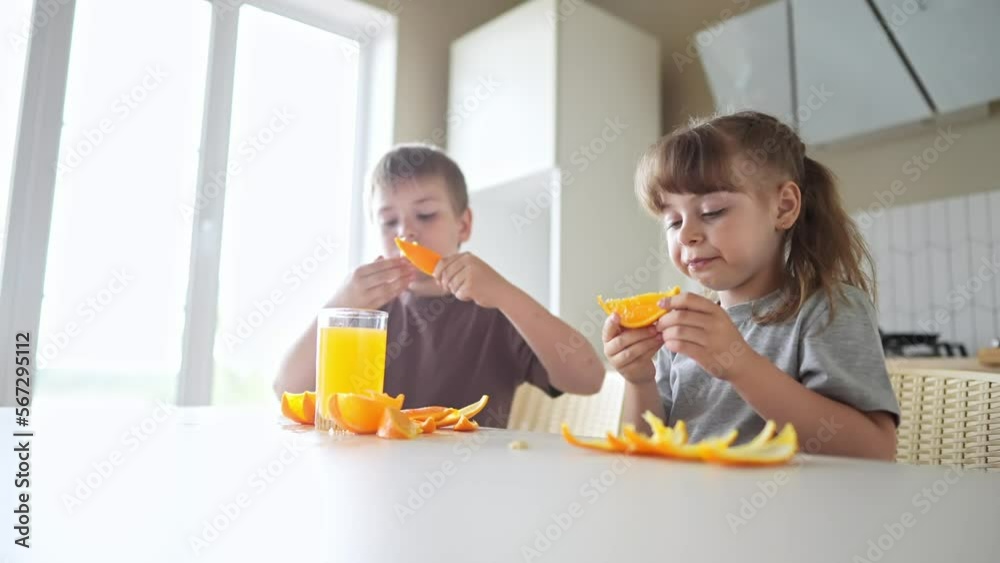 children eat oranges. happy family a kid dream concept. drinking fresh juices. morning breakfast brother and sister eat oranges in the kitchen. fruits orange juice healthy fun eating children eat oranges. happy family a kid dream concept. drinking fresh juices. morning breakfast brother and sister eat oranges in the kitchen. fruits orange juice healthy fun eating