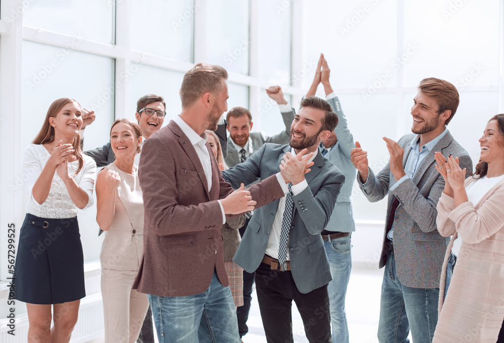 © ASDF - happy young business man accepting congratulations from his colleagues.