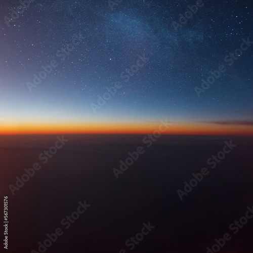Amazing sunset in the sky with stars and clouds. Photo from the plane. Travel and flight concept