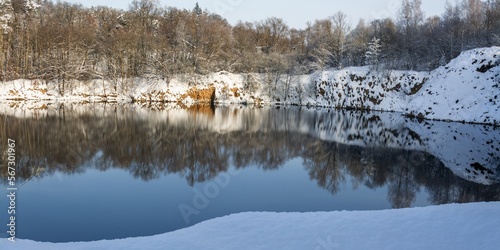 View into a snowy old flooded quarry. Opatovice. Central Moravia. Czechia. photo
