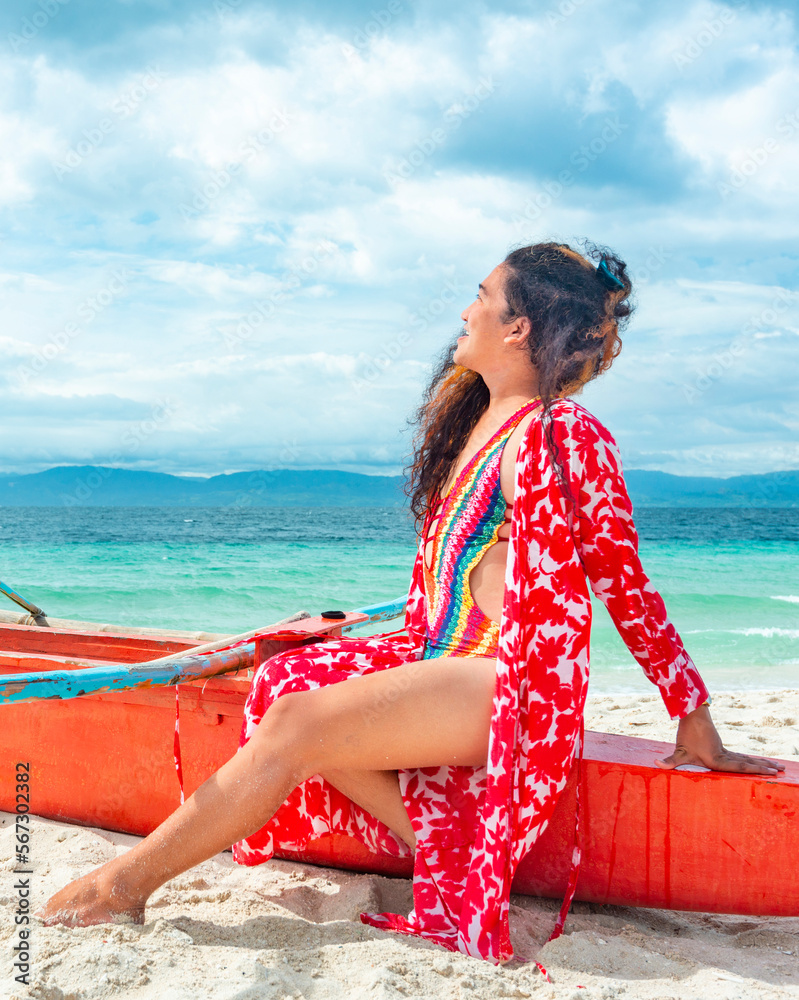 Foto Stock Transgender woman posing in colorful swimwear,on a boat,White  Beach,Moalboal,Cebu Island,Philippines. | Adobe Stock