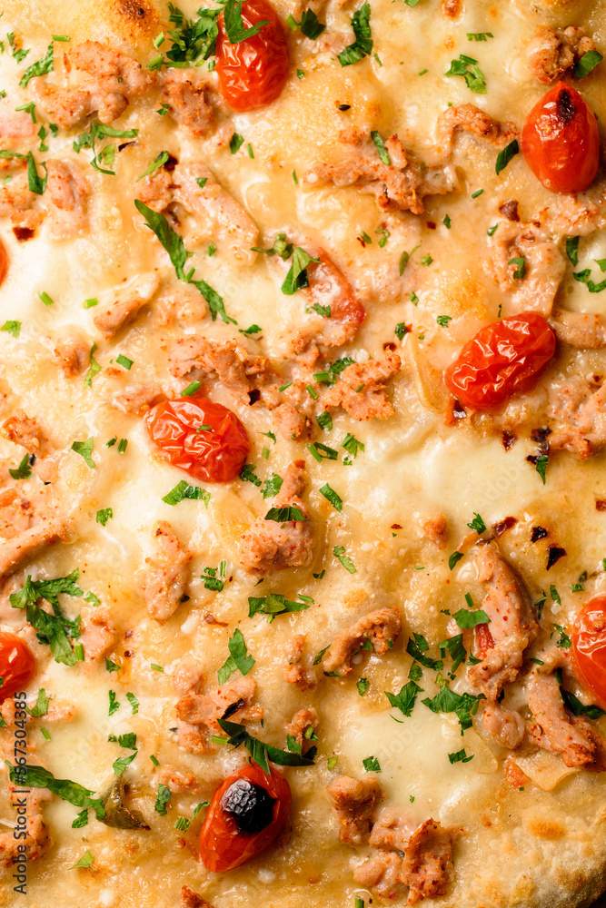 Close-up top view on pizza topping with cherry tomatoes and chicken garnished by green