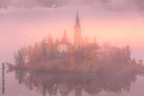 Morning aerial sunrise view of Lake Bled with St. Marys Church  Slovenia in the fog and autumn trees