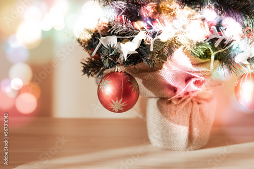 Small Christmas tree decorated with dangling red bubble and ornaments. Light effects