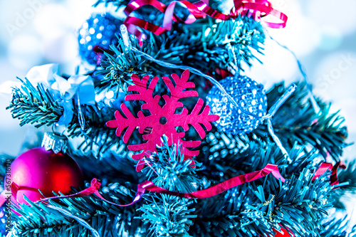 Close up of a decorated Christmas tree with red snowflake and bubble and silver balls