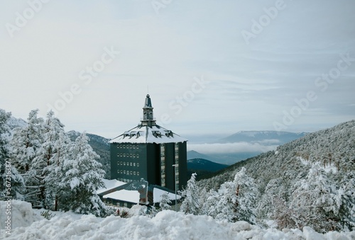 snowy landscape with mountains and a building of the sierra de navacerrada in madrid photo