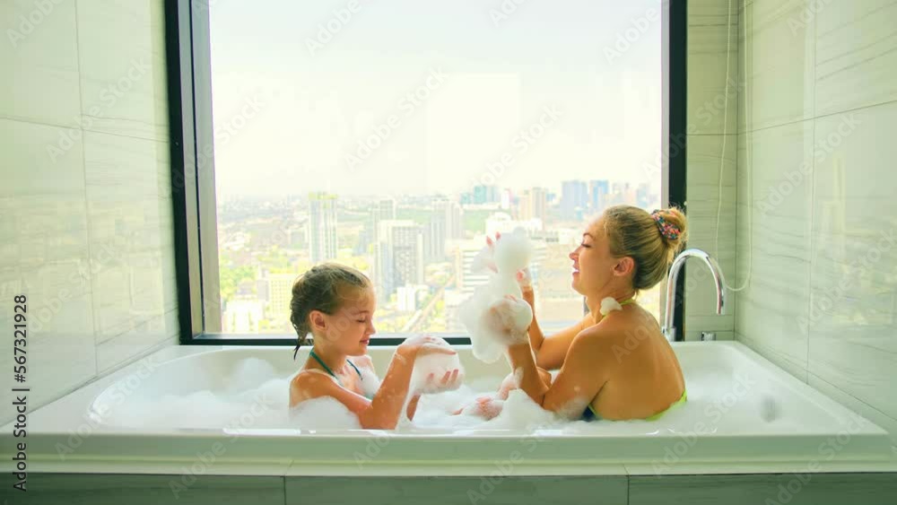 Funny mother and daughter bonding activity, play with foam, laughing