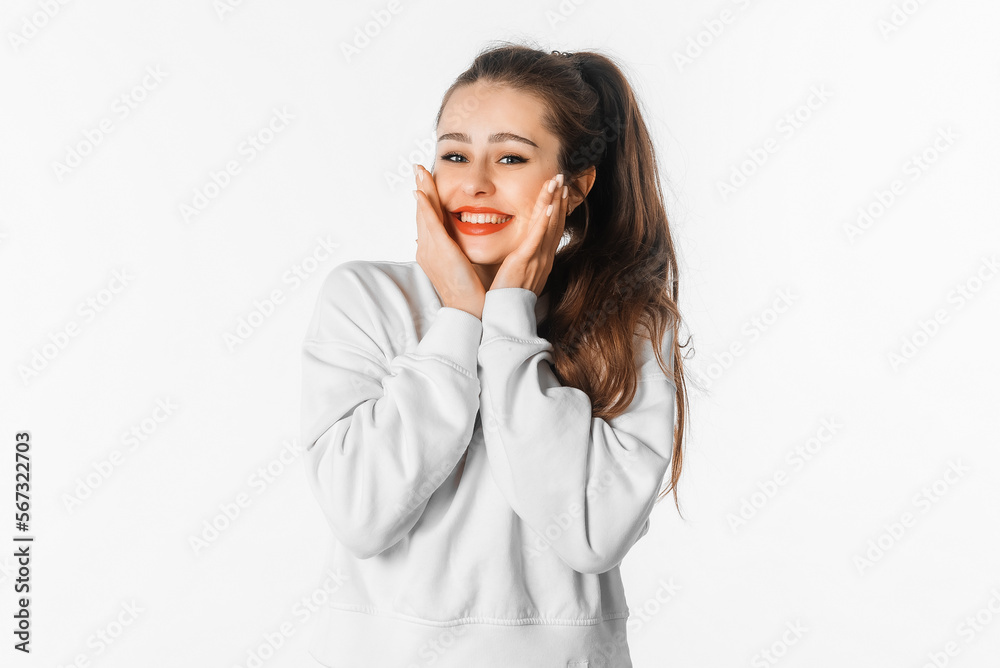 Shy. Happy pretty young woman with long hair, smiling, looking silly and cute, daydreaming, feeling excitement over smth, stands over white background Shy. Happy pretty young woman with long hair, smiling, looking silly and cute, daydreaming, feeling excitement over smth, stands over white background