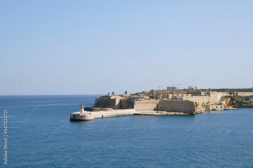 view of the red lighthouse near Fort Ricasoli East Breakwater - Malta.