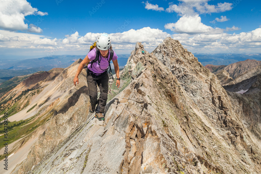 Women climb narrow ridge on Capitol Peak, Elk Mountains, Colorado Women climb narrow ridge on Capitol Peak, Elk Mountains, Colorado