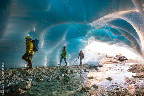 Adventure guide brings two female clients into a glacial cave. photo