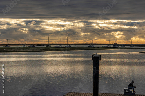 Lonely man watches a beautiful sunset on the marshlands