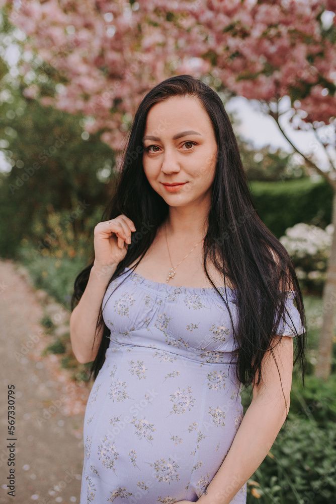 portrait of pregnant woman in park with magnolia tree portrait of pregnant woman in park with magnolia tree