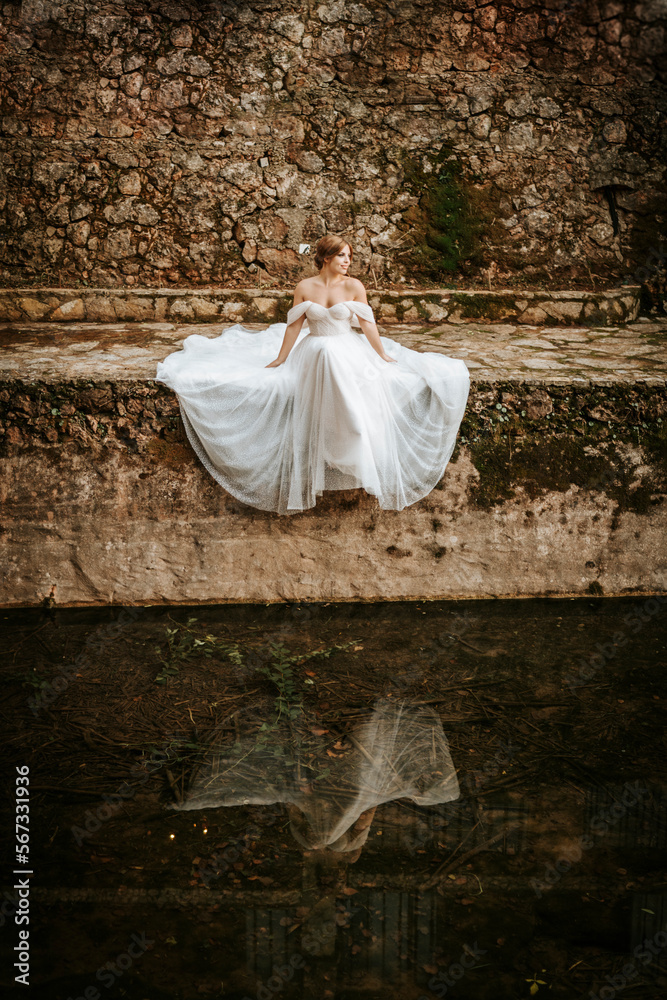 Dreamy portraits of beautiful bride on stone riverbank Dreamy portraits of beautiful bride on stone riverbank