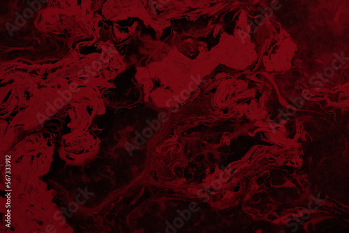 Spilled red paint on a thinner solution forming an abstract pattern. Selective focus on black background.