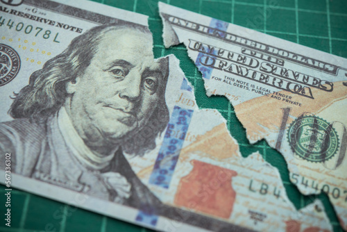 Tear off US dollar bill banknote as chart graph falling down. The Federal Reserve ( FED ) increase % interest rates to fix inflation crisis. World global economy recession and stagflation concept. photo
