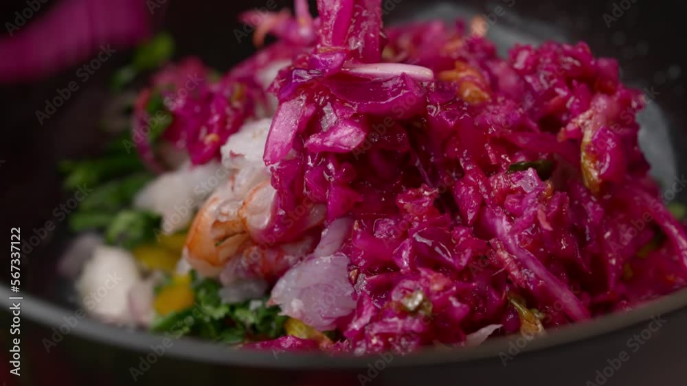 Chef prepares cebiche by placing red onion and prawns in a bowl with coriander and yellow pepper. Chef prepares cebiche by placing red onion and prawns in a bowl with coriander and yellow pepper.