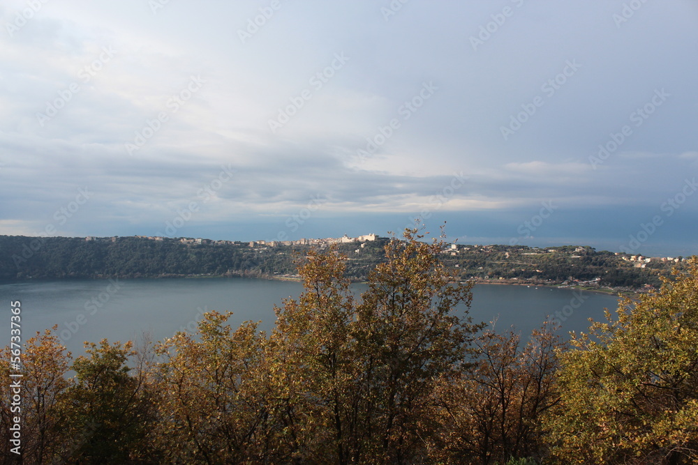 
View of Albano lake near Castelgandolfo and the summer palace of the Pope, general view of Nemi lake and houses in Nemi town, fountain, sales counter of wild strawberries, Lazio Rome Italy