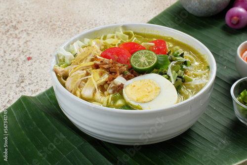 soto ayam, chicken soup with a yellow sauce photo