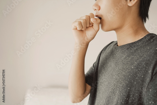 Close up of teen boy coughing from cold and flu,COPD, pneumonia, bronchitis, asthma, allergy, respiratory illness concept
