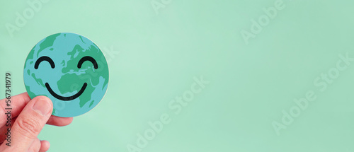 Fototapeta Naklejka Na Ścianę i Meble -  Hands holding earth with smile face, save planet, earth day, environment day, happy world, csr, sustainable living, world peace day concept