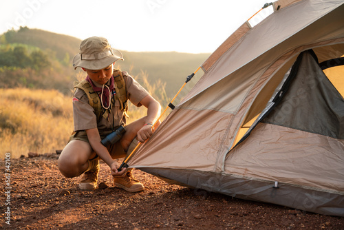 Asian Boy Scouts attending Scout camp pitching their tents in a Boy Scout camp on a mountain near sunset.