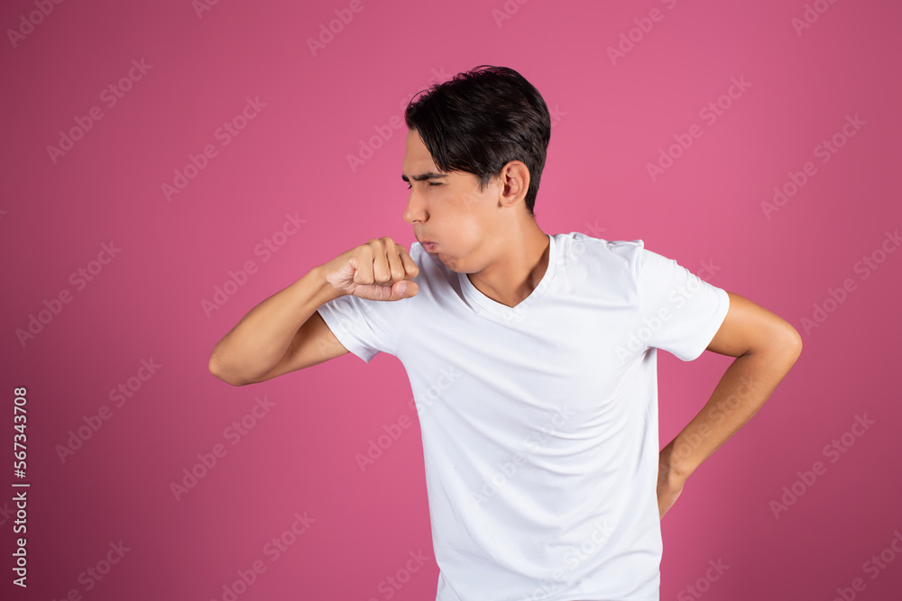 The man coughs. Sick student on a pink background. The man coughs. Sick student on a pink background.