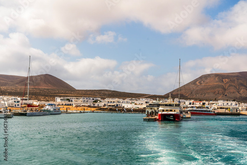 Small harbor with touristic ferries commuting people between La Graciosa and Lanzarote, Caleta del Sebo, Canary Islands photo