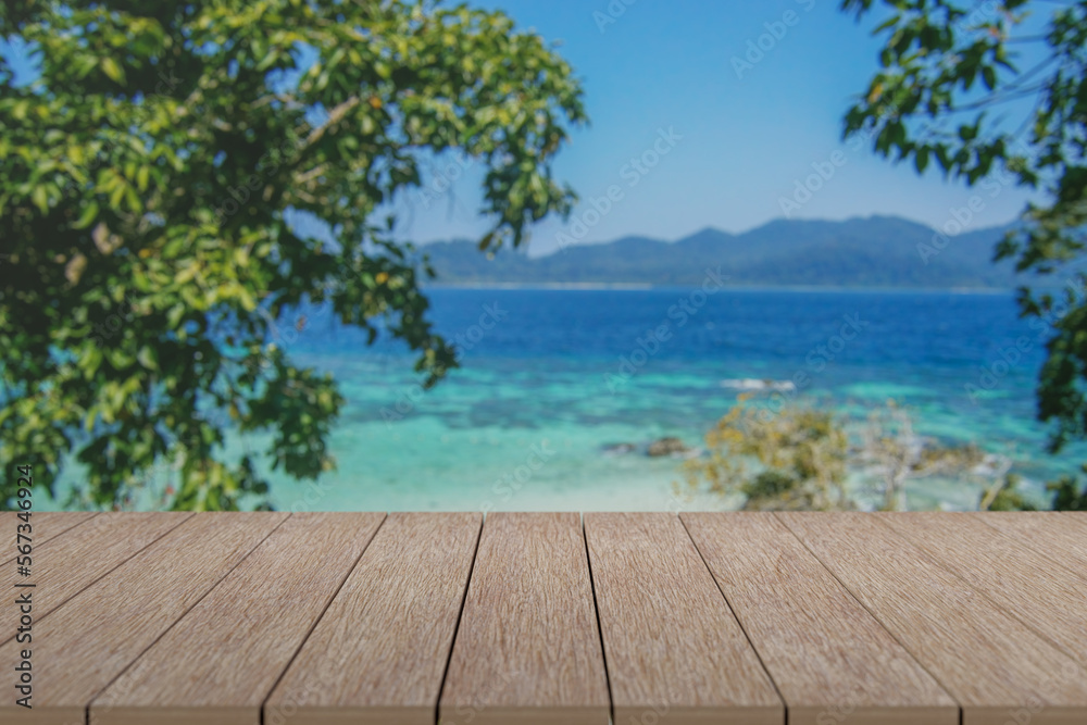 Fototapeta premium Wooden table with view of beautiful beach and sea with turquoise water.