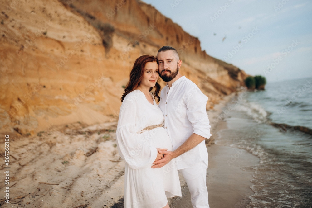 a guy with a girl in white clothes on the seashore