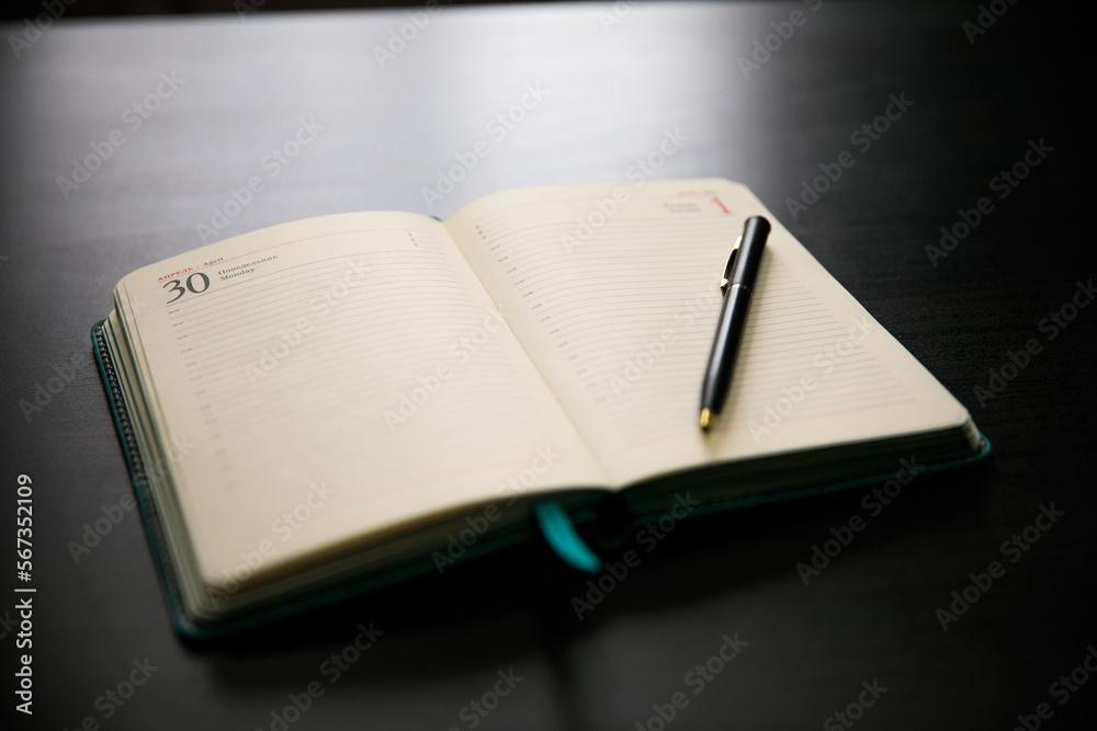 open diary with a pen on a dark background open diary with a pen on a dark background