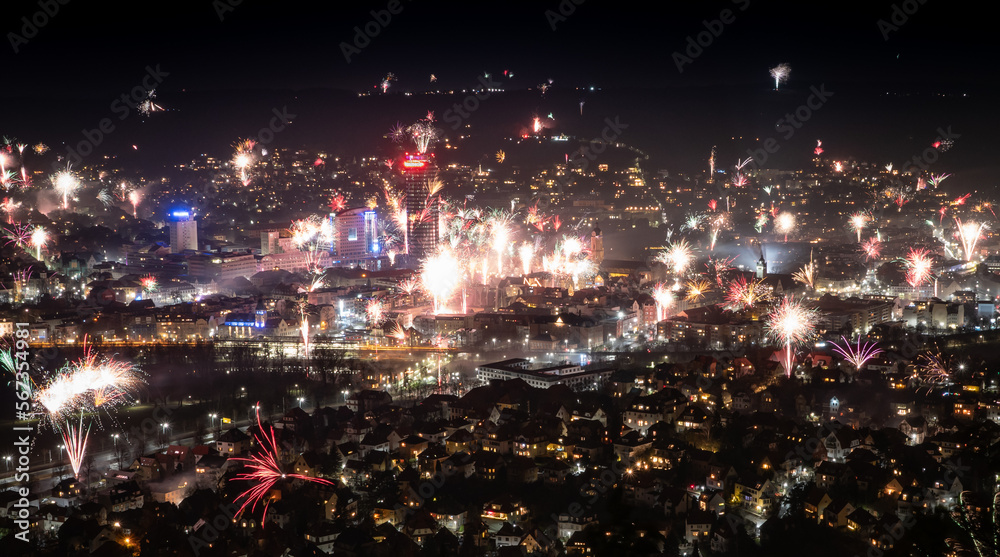 Fototapeta premium Germany discusses Prohibition of pribate fireworks: Night View of Town on New Year's Eve With Fireworks. Jena, Thuringia, Germany 