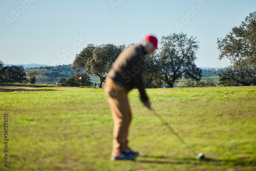 senior man playing golf focus on background