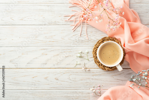 Hello spring concept. Top view photo of cup of frothy coffee on rattan placemat gypsophila flowers and pink soft plaid on grey wooden desk background with copyspace