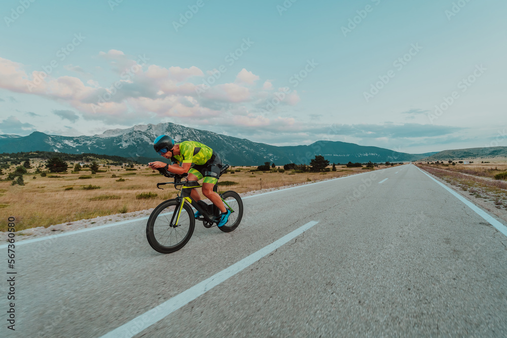 Full length portrait of an active triathlete in sportswear and with a protective helmet riding a bicycle. Selective focus Full length portrait of an active triathlete in sportswear and with a protective helmet riding a bicycle. Selective focus