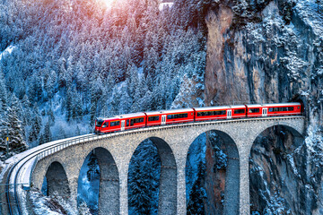 Aerial view of Train passing through famous mountain in Filisur, Switzerland. Landwasser Viaduct world heritage with train express in Swiss Alps snow winter scenery.