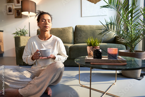 Foto Mixed race woman enjoying the peace at home with cup of coffee