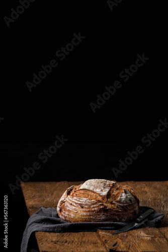 Rustic crispy sourdough bread with cranberries on a wooden table. Vertical panoramic view, free space for text