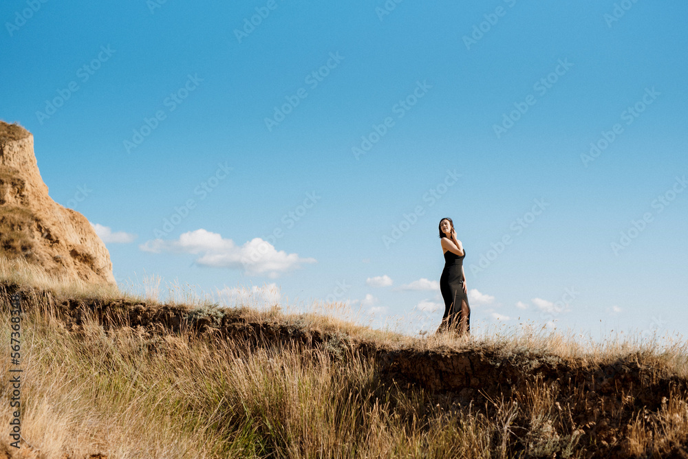 tall girl model in a black dress on the mountain hills tall girl model in a black dress on the mountain hills