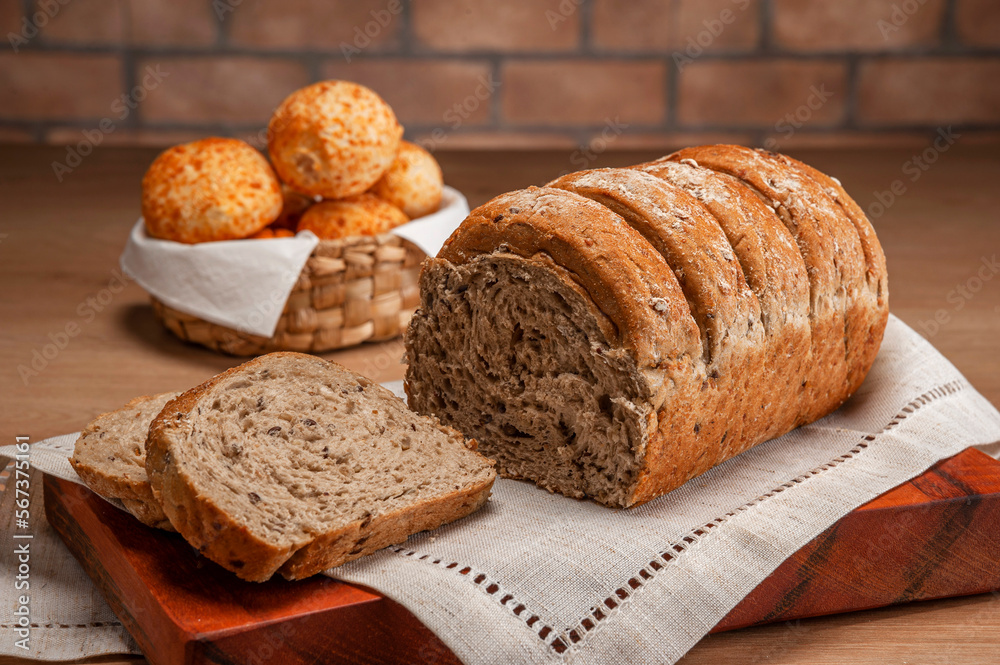 Wholemeal bread with cheese breads on a basket behinden. Wholemeal bread with cheese breads on a basket behinden.