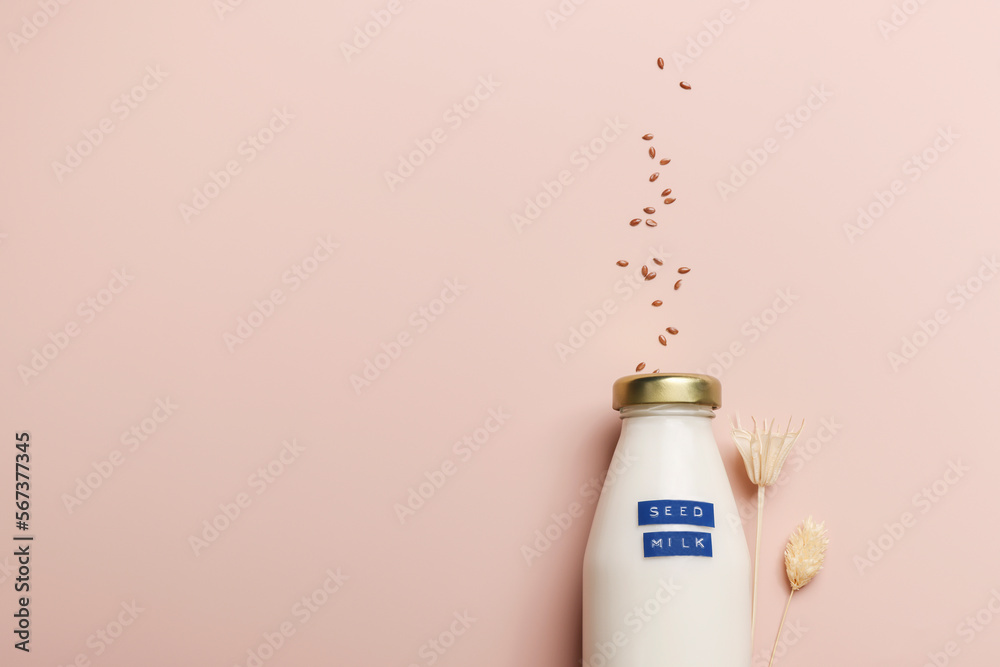 flax seed milk in bottle on beige background with plant. copy space. Raw diet meal. Healthy vegetarian food and lifestyle. eco friendly product flax seed milk in bottle on beige background with plant. copy space. Raw diet meal. Healthy vegetarian food and lifestyle. eco friendly product