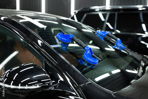 Glass of the car is a close-up in the room, removed with the help of professional suction cups. The process of car repair.