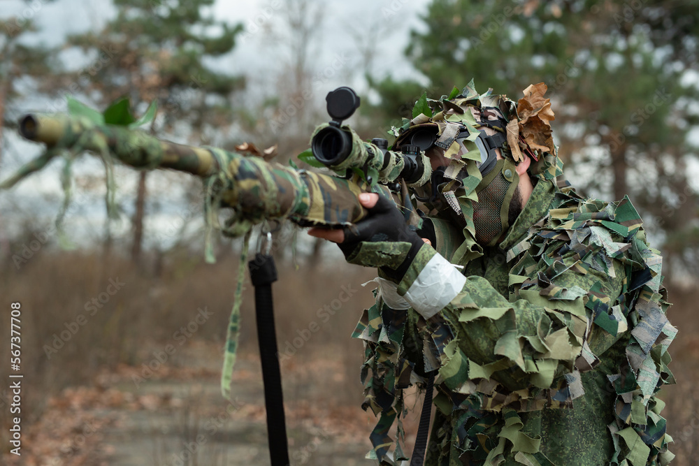 Sniper aiming from his rifle in forest.